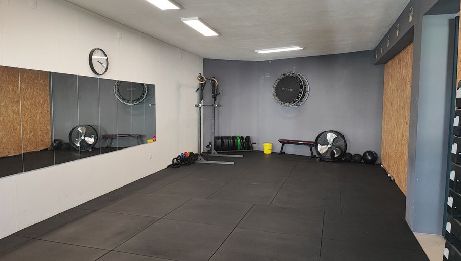 Espaço de treino moderno no Transform Fitness Studio, Romariz, Aveiro, PT, com espelhos e equipamentos.