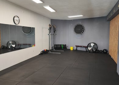 Espaço de treino moderno no Transform Fitness Studio, Romariz, Aveiro, PT, com espelhos e equipamentos.