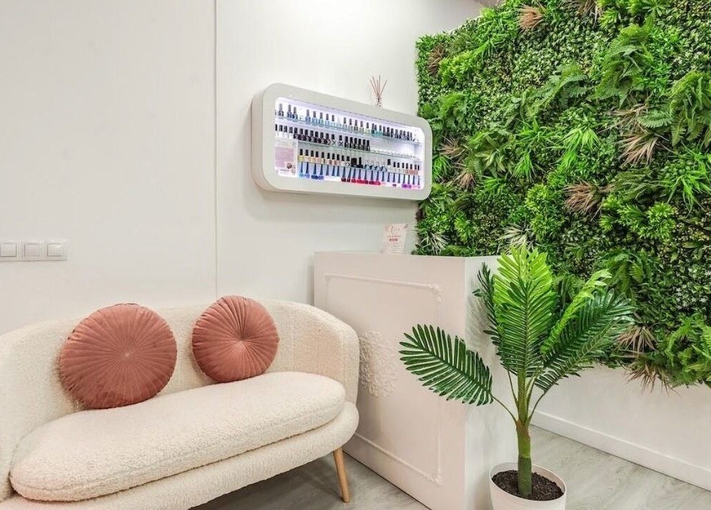 Acogedora sala de espera en WOW Nails Getafe, Getafe, Comunidad De Madrid, ES, con pared verde exuberante.