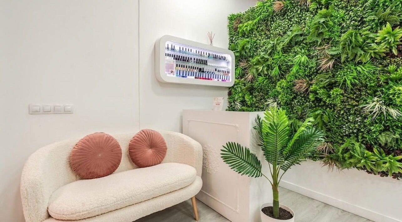 Acogedora sala de espera en WOW Nails Getafe, Getafe, Comunidad De Madrid, ES, con pared verde exuberante.