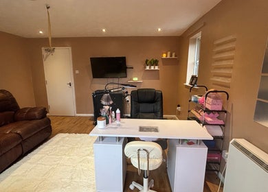 Nail salon at Koated by Kenya in London, England, GB, featuring a plush couch and sleek manicure station.
