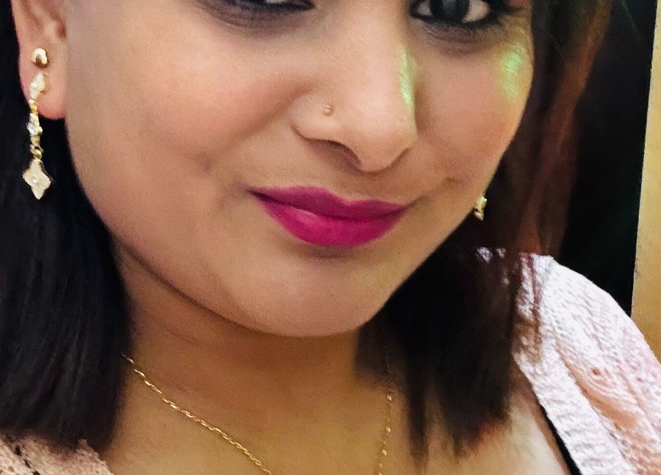 Close-up of a smiling woman at Sanjula Bagdas Beauty Salon in Dubai, AE wearing elegant jewelry.