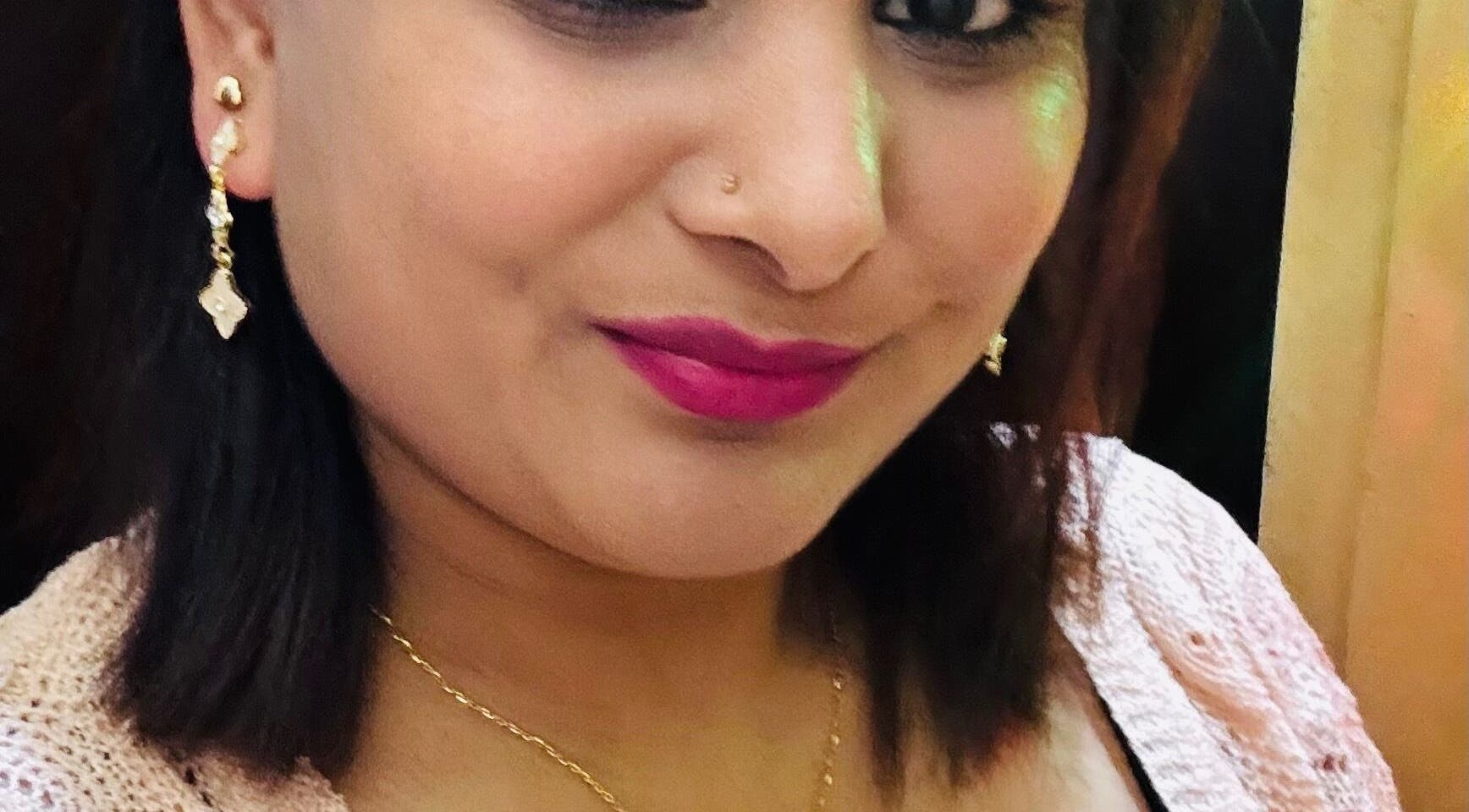 Close-up of a smiling woman at Sanjula Bagdas Beauty Salon in Dubai, AE wearing elegant jewelry.