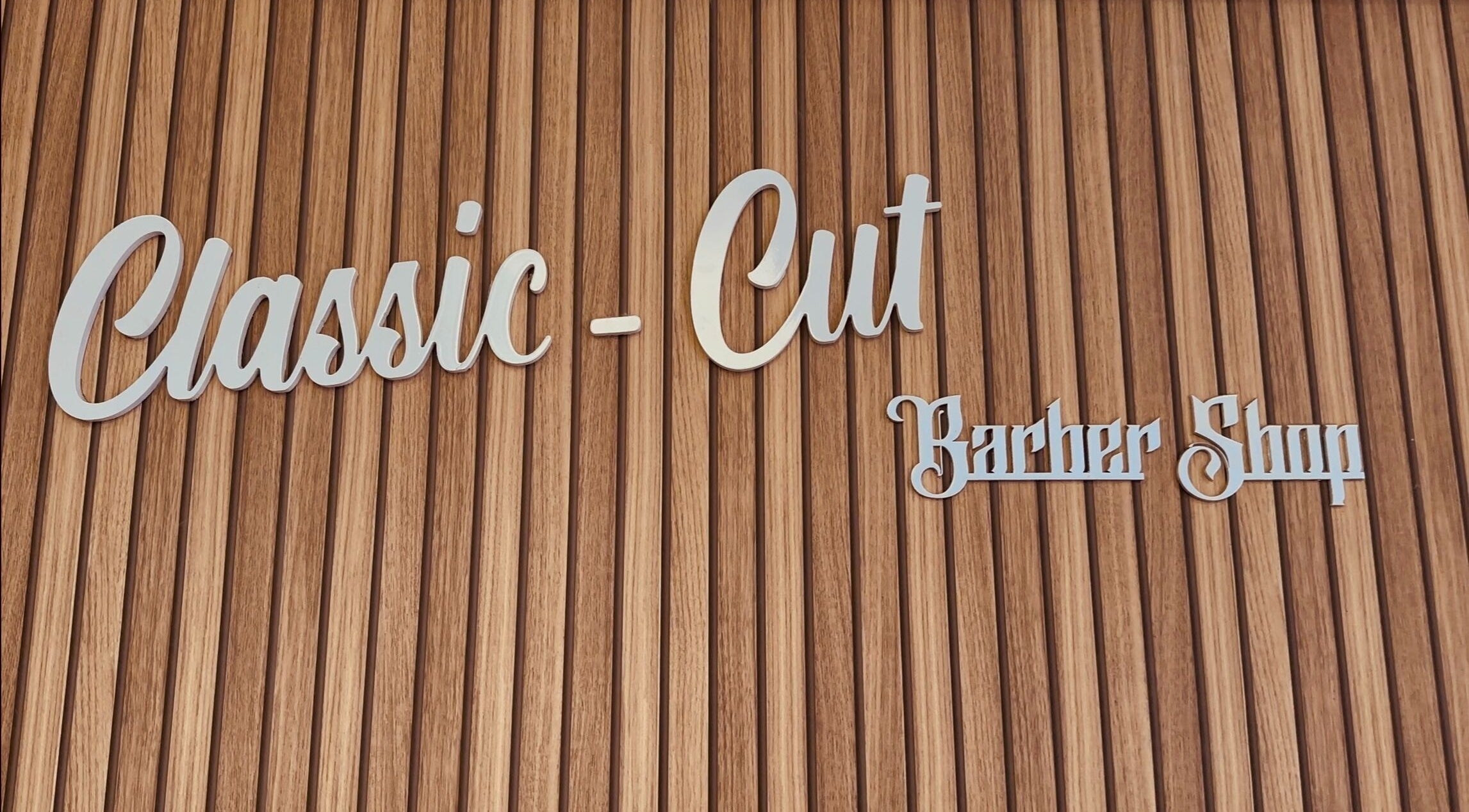 Enseigne de Classic-Cut barber shop à Saint-louis, Saint-pierre, RE sur fond en bois sophistiqué.