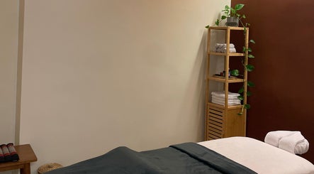 Tranquil massage room at Sureechai Massages in Hove, Vlaanderen, BE with cozy bed and soothing decor.