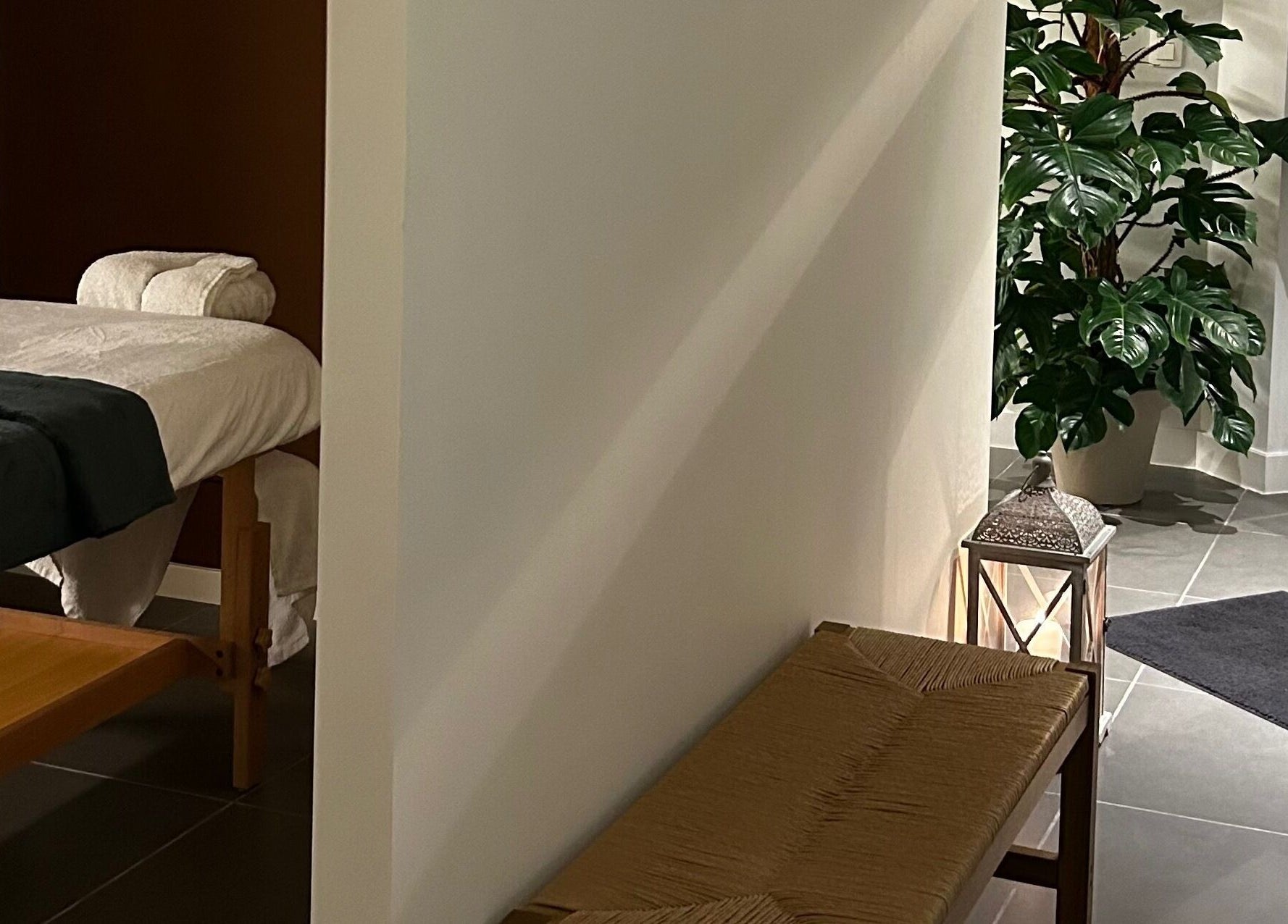 Tranquil massage room at Sureechai Massages, Hove, Vlaanderen, BE, featuring a comfortable massage table and lush greenery.