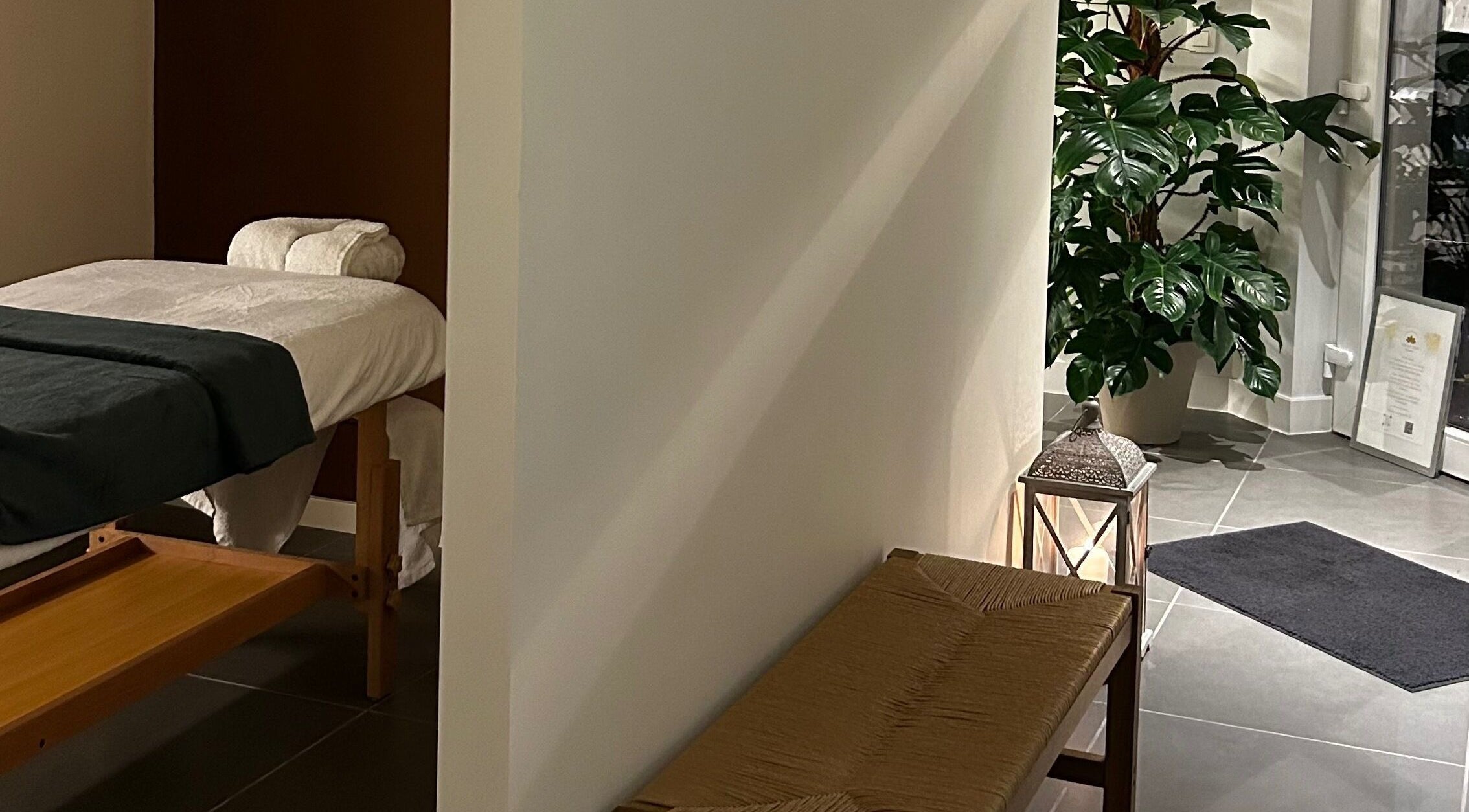 Tranquil massage room at Sureechai Massages, Hove, Vlaanderen, BE, featuring a comfortable massage table and lush greenery.