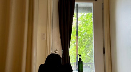 Relaxing corner at Em-Bodywellness in Montréal, Québec, CA, featuring a cozy seat and window view.