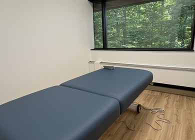 Relaxing massage room at Xiomara Wellness Massage in Avon, Connecticut, US with a view of lush greenery.