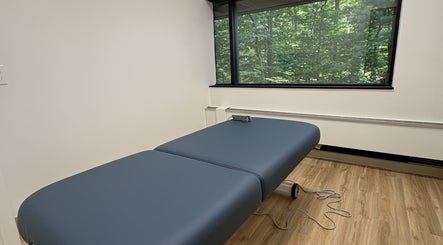 Relaxing massage room at Xiomara Wellness Massage in Avon, Connecticut, US with a view of lush greenery.
