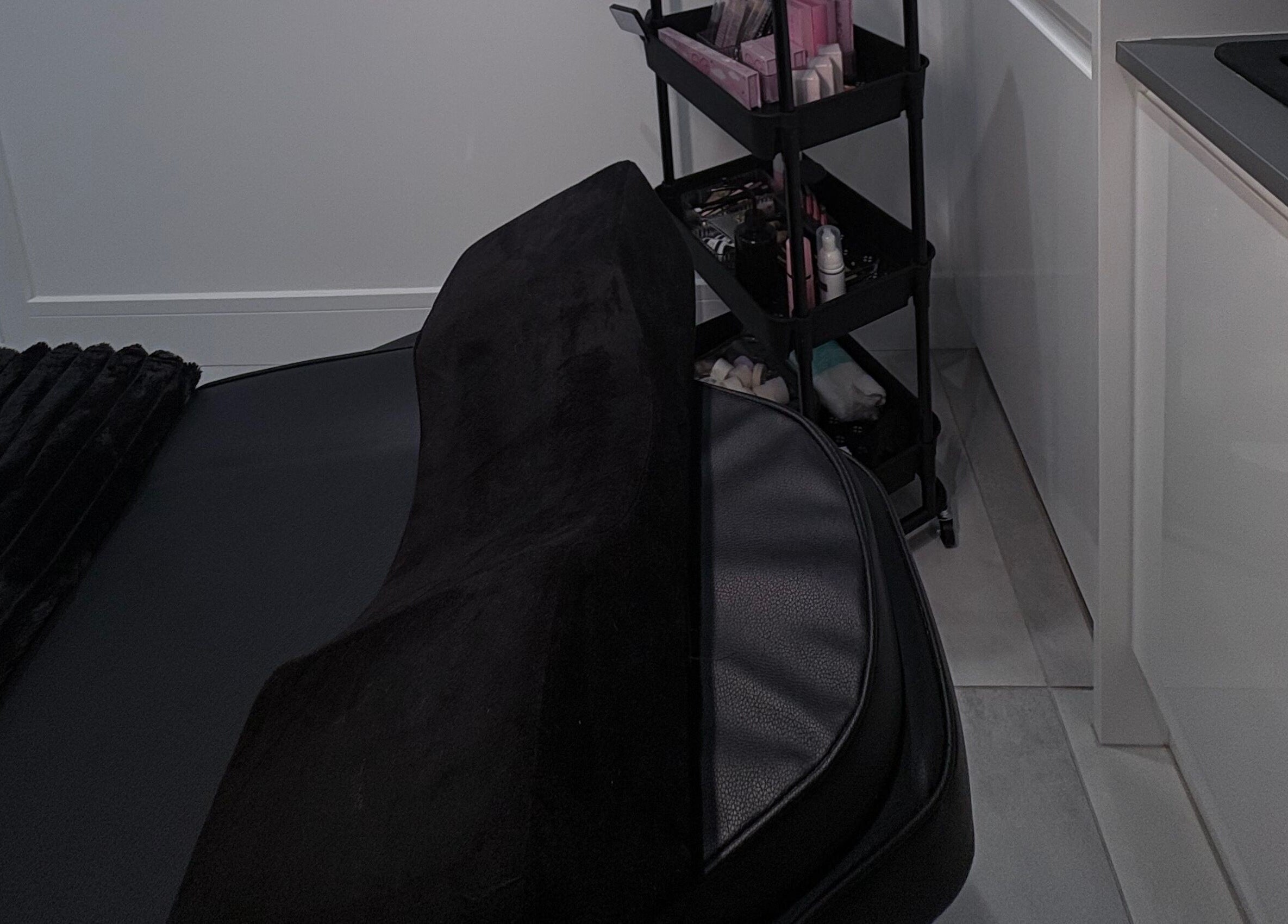 Cozy treatment bed with black cushion and cosmetics at Ova Beauty Bar, Banchory, Scotland, GB.