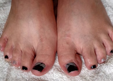 Pedicura con esmalte negro en LuNails Muros, Muros, ES, destacando en un fondo blanco.