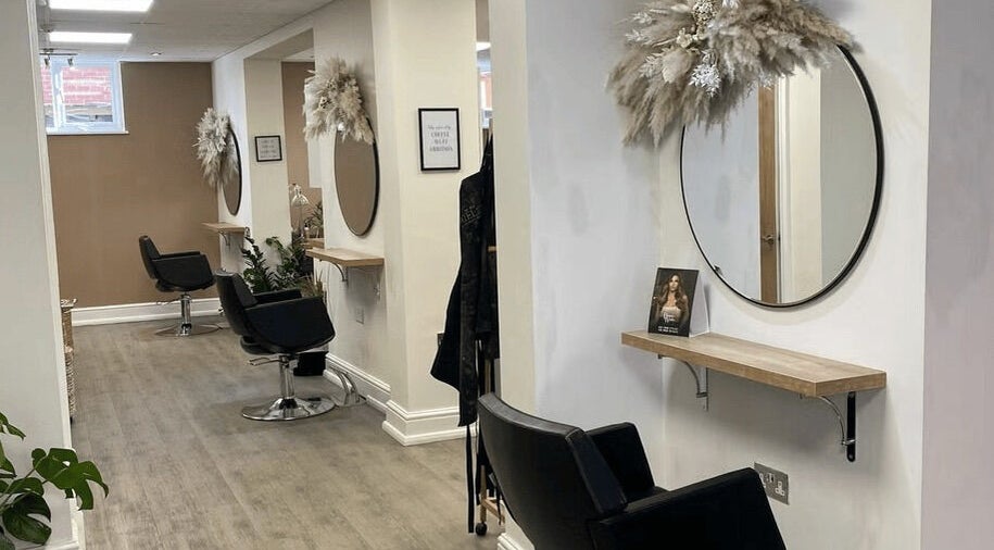 Stylish interior of Quality Braids by Grace in St. Louis Park, Minnesota, US featuring sleek salon chairs and mirrors.