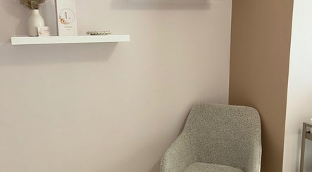 Coin salon élégant chez Lunea Beauté à Sucy-en-Brie, Île-de-France, FR avec chaise grise et étagère décorée.