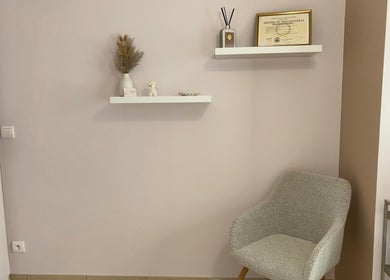 Coin cosy chez Lunea Beauté, Sucy-en-brie, Île-de-france, FR, avec chaise grise et étagères murales élégantes.