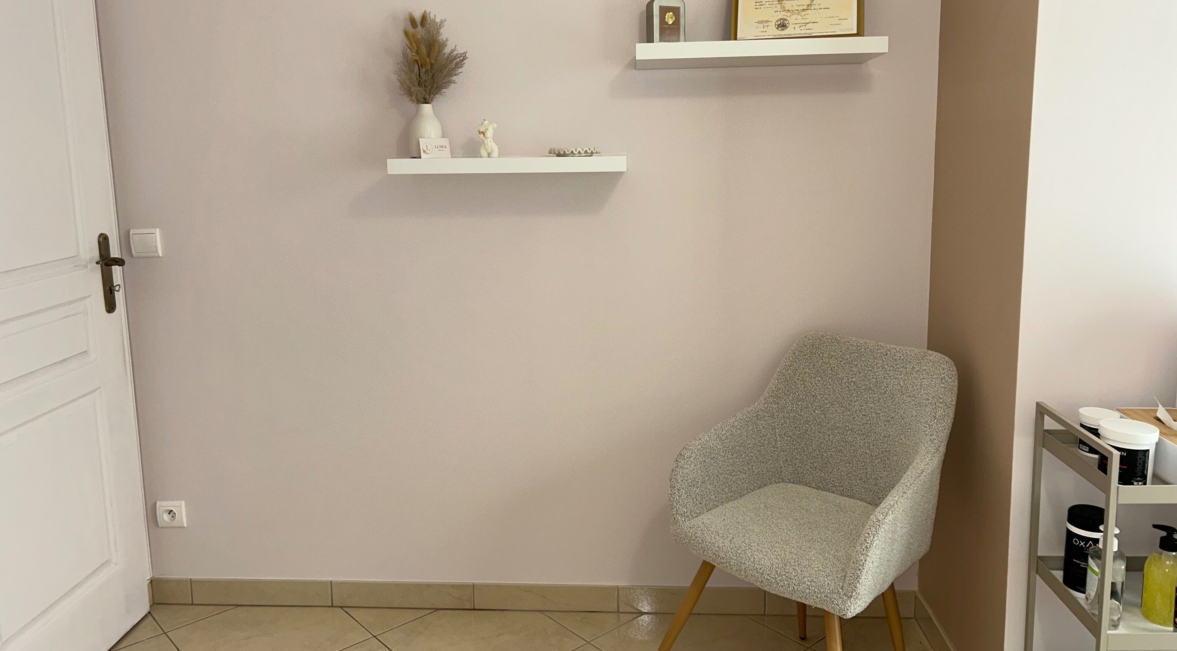 Coin détente à Lunea Beauté, Sucy-en-brie, Île-de-france, FR avec chaise grise et étagères décoratives.