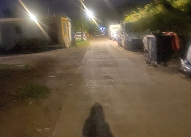 Dimly lit street near tewcutebraidingbylea in French Quarter, SX with parked cars and streetlights.