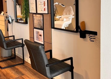 Interieur van Roya Beautycenter in Woerden, Utrecht, NL met moderne kappersstoelen en spiegels.