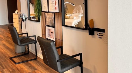Interieur van Roya Beautycenter in Woerden, Utrecht, NL met moderne kappersstoelen en spiegels.