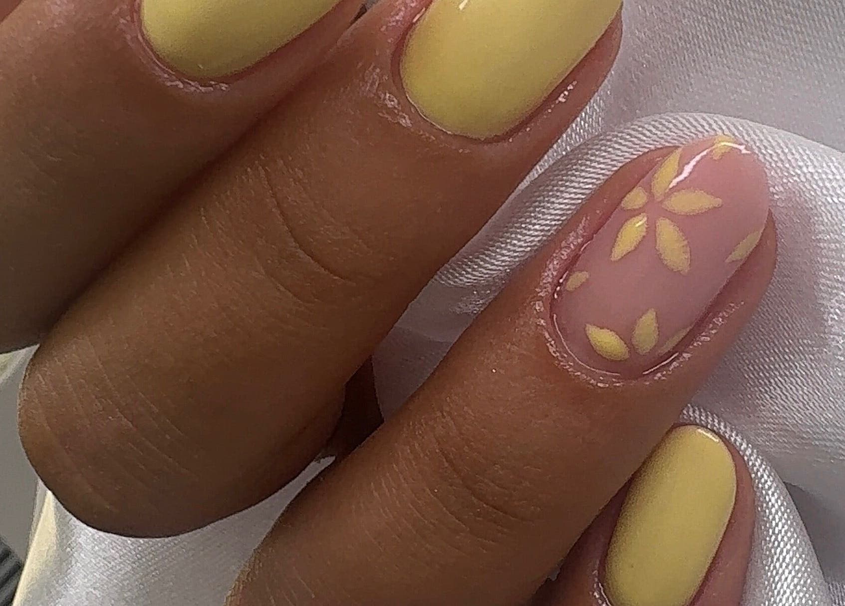 Manicure floral amarela no Studio Amorim em Namur, Région Wallonne, BE, destacando arte delicada.