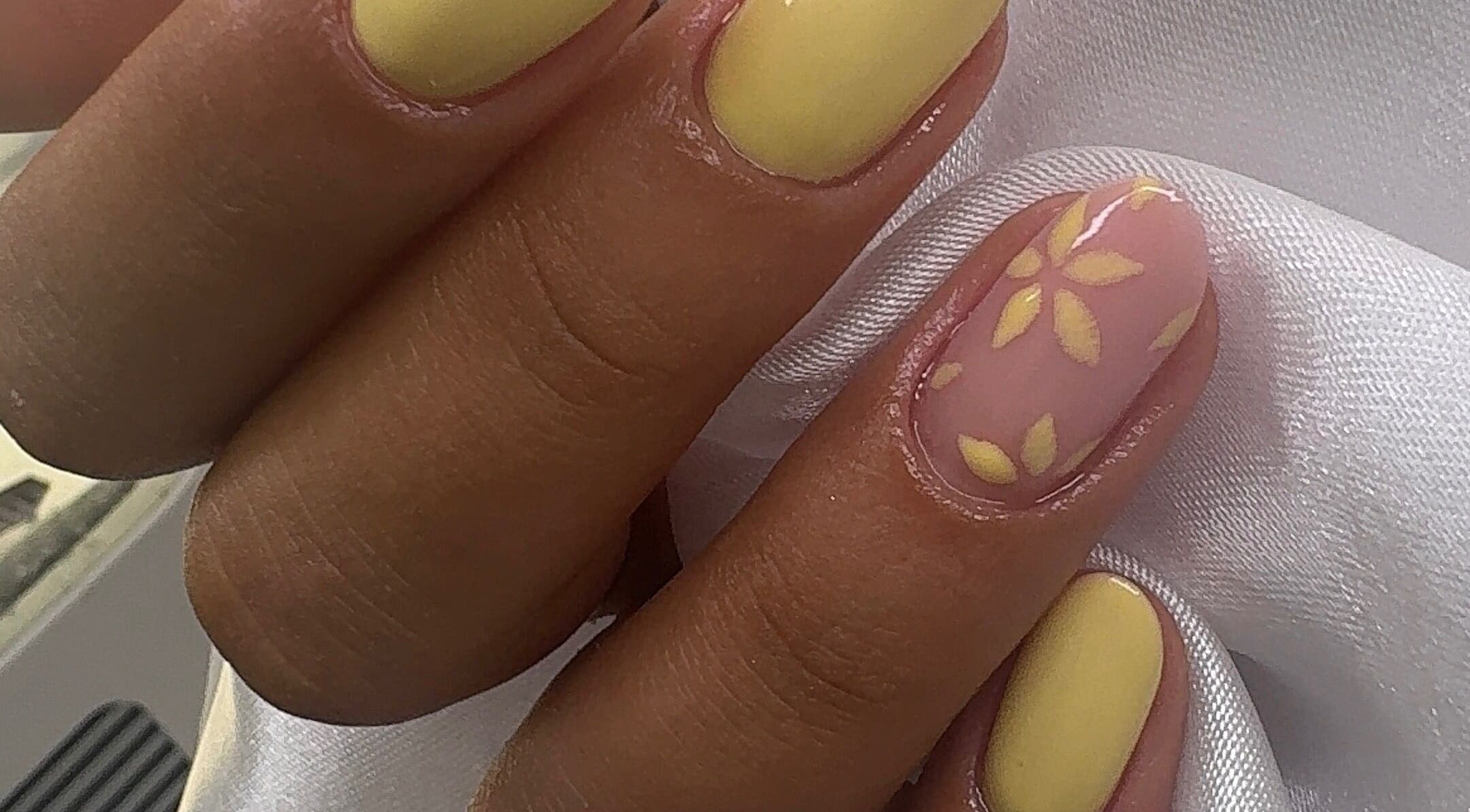 Manicure floral amarela no Studio Amorim em Namur, Région Wallonne, BE, destacando arte delicada.