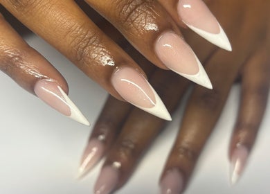 Stylish stiletto nails with French tips at Nailedbyjc in Grays, England, GB.