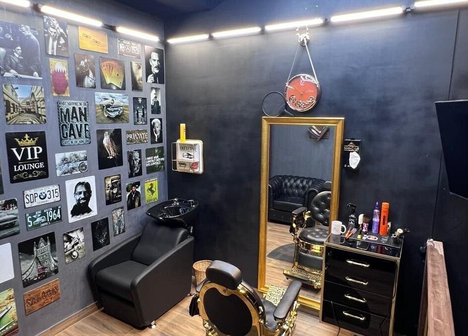 Stylish interior of MAN CAVE SALON in Doha, Doha Municipality, QA with black decor and wall art.