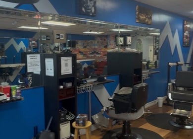 Interior of KROWNED by P, a modern salon in Tamarac, Florida, US with blue walls and barber chairs.