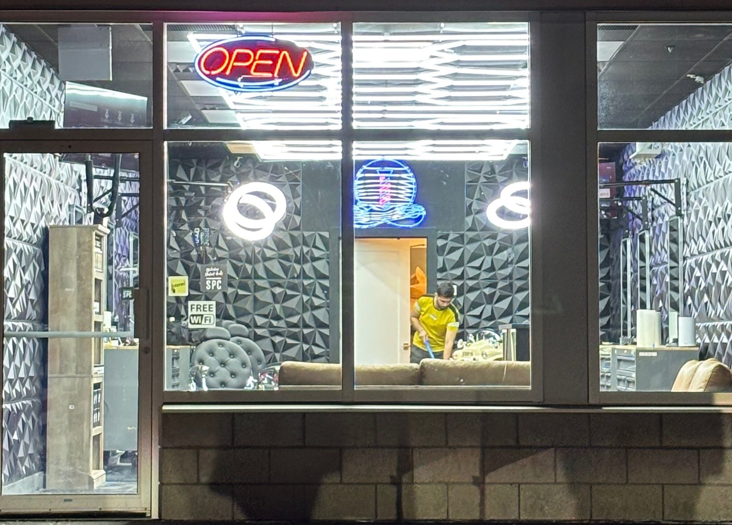 Joseph Howe barbershop with vibrant interior in Halifax, Nova Scotia, CA, visible through large glass window.
