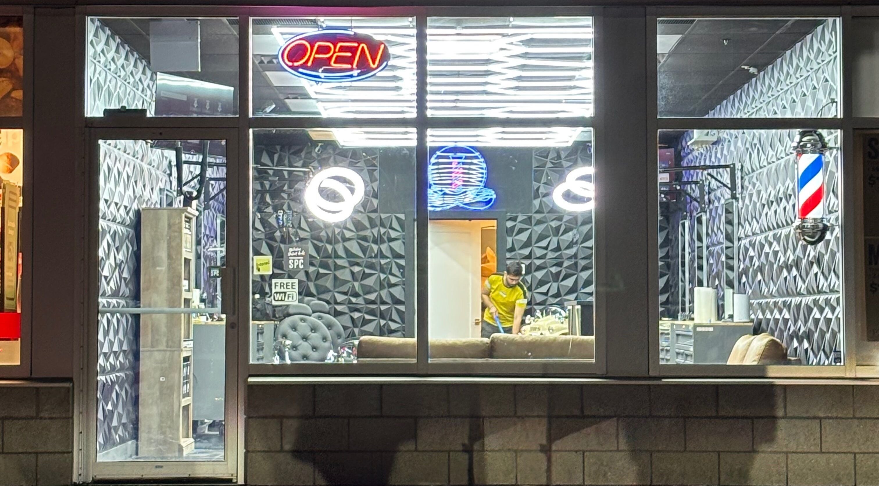 Joseph Howe barbershop with vibrant interior in Halifax, Nova Scotia, CA, visible through large glass window.