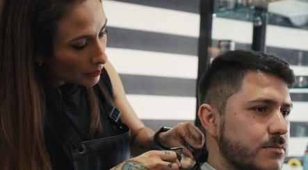 Estilista en Barberia militar, San Bernardo, Región Metropolitana, CL, realizando corte preciso a un cliente.