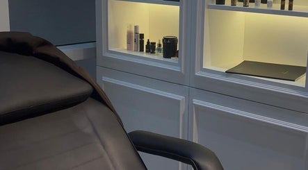 Cabine de soin élégante chez So Chic Paris à Dubai, Dubai, AE avec produits de beauté sur étagères éclairées.