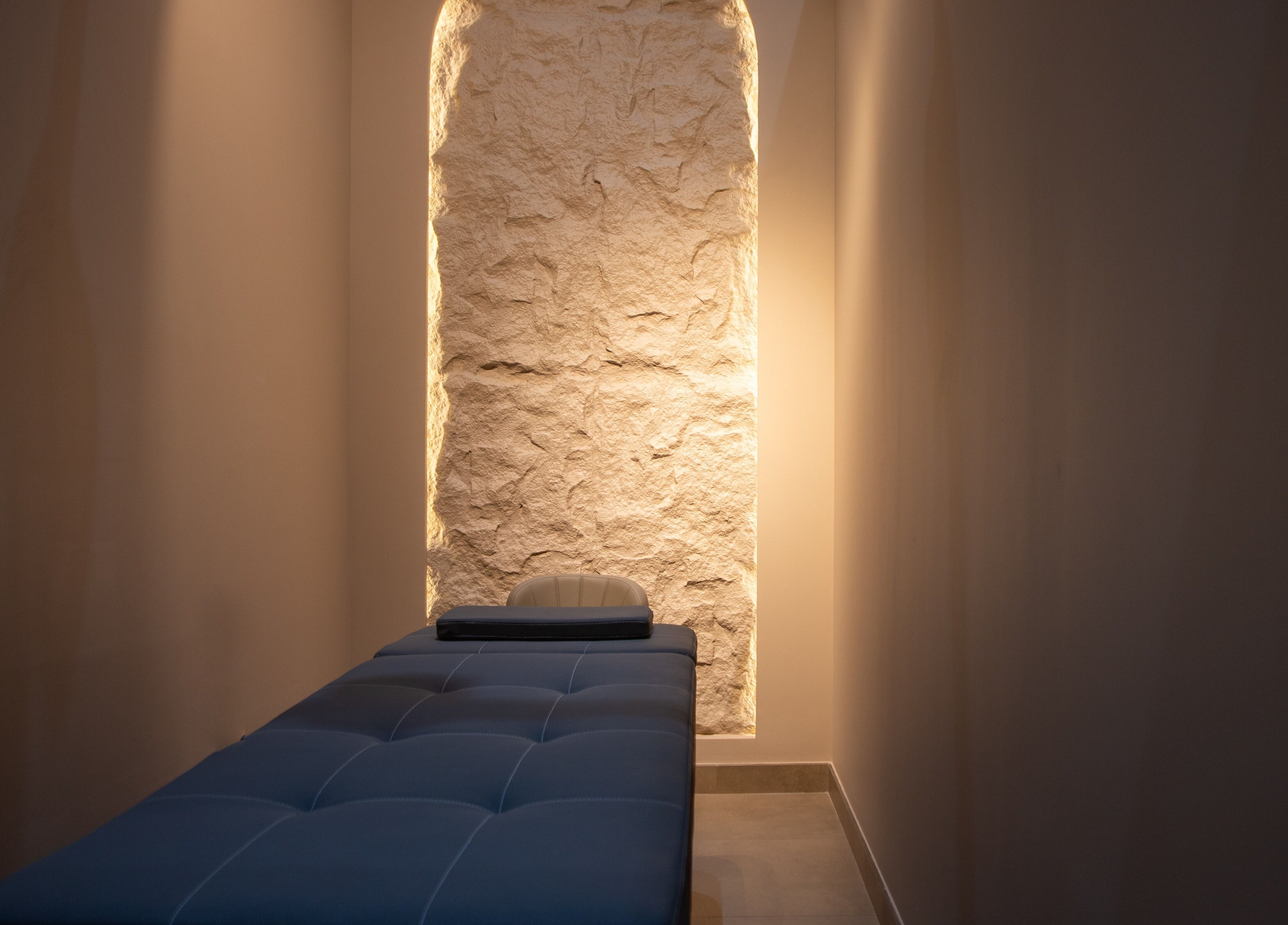 Serene massage room at So Chic Paris, Dubai, Dubai, AE with ambient lighting and a plush massage table.
