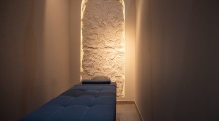 Serene massage room at So Chic Paris, Dubai, Dubai, AE with ambient lighting and a plush massage table.