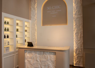 Elegant reception area of So Chic Paris in Dubai, Dubai, AE with illuminated shelves and modern decor.