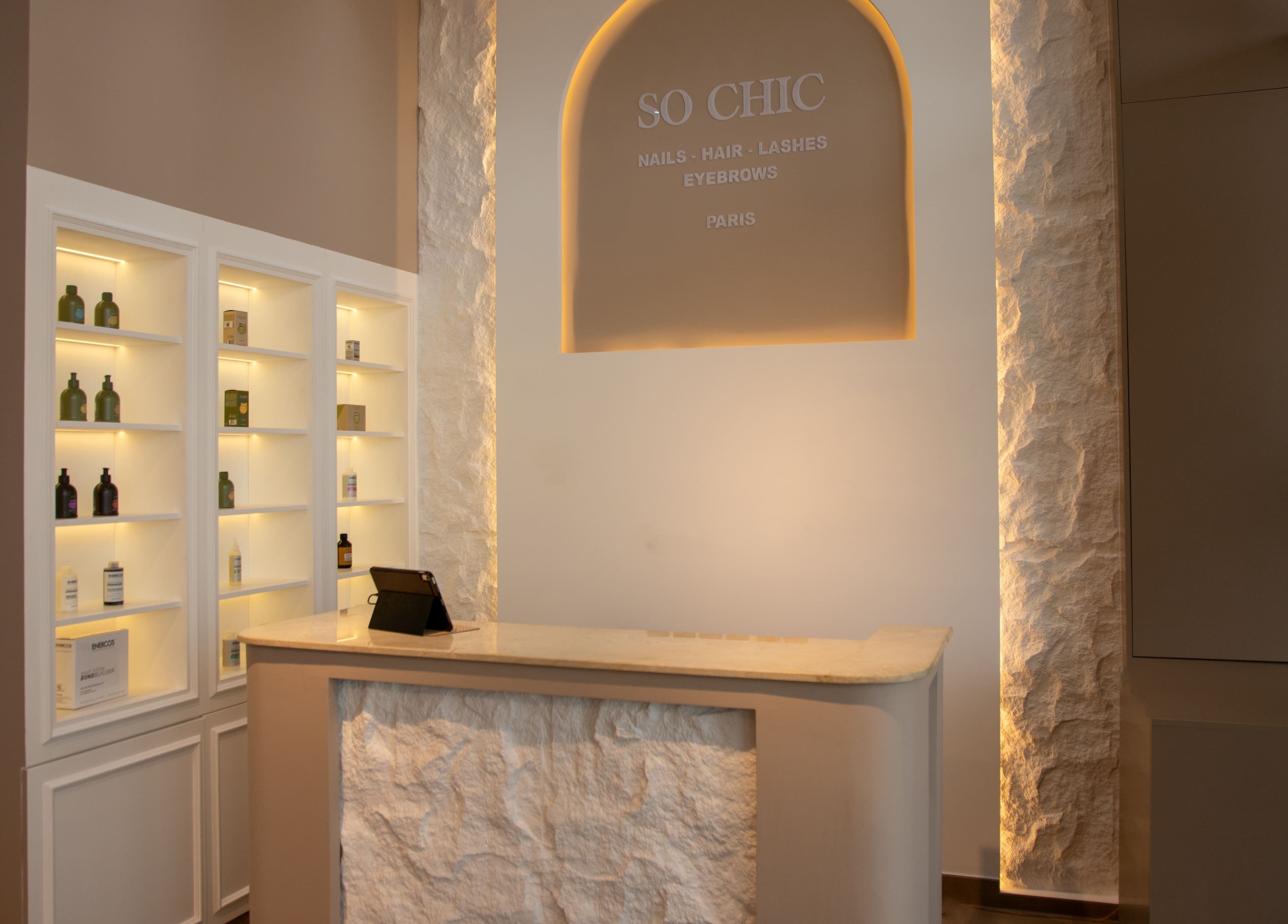 Elegant reception area of So Chic Paris in Dubai, Dubai, AE with illuminated shelves and modern decor.