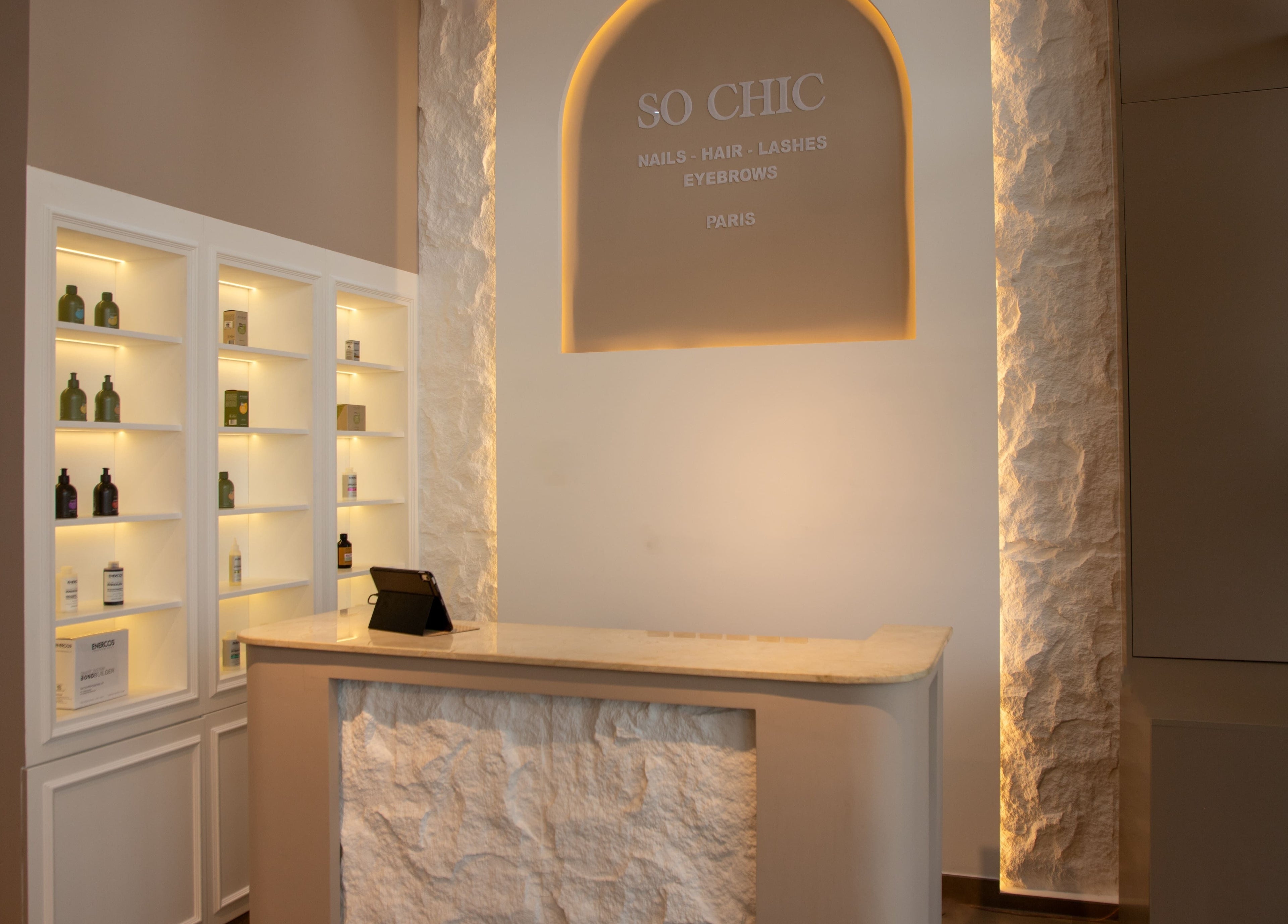 Elegant reception area of So Chic Paris in Dubai, Dubai, AE with illuminated shelves and modern decor.