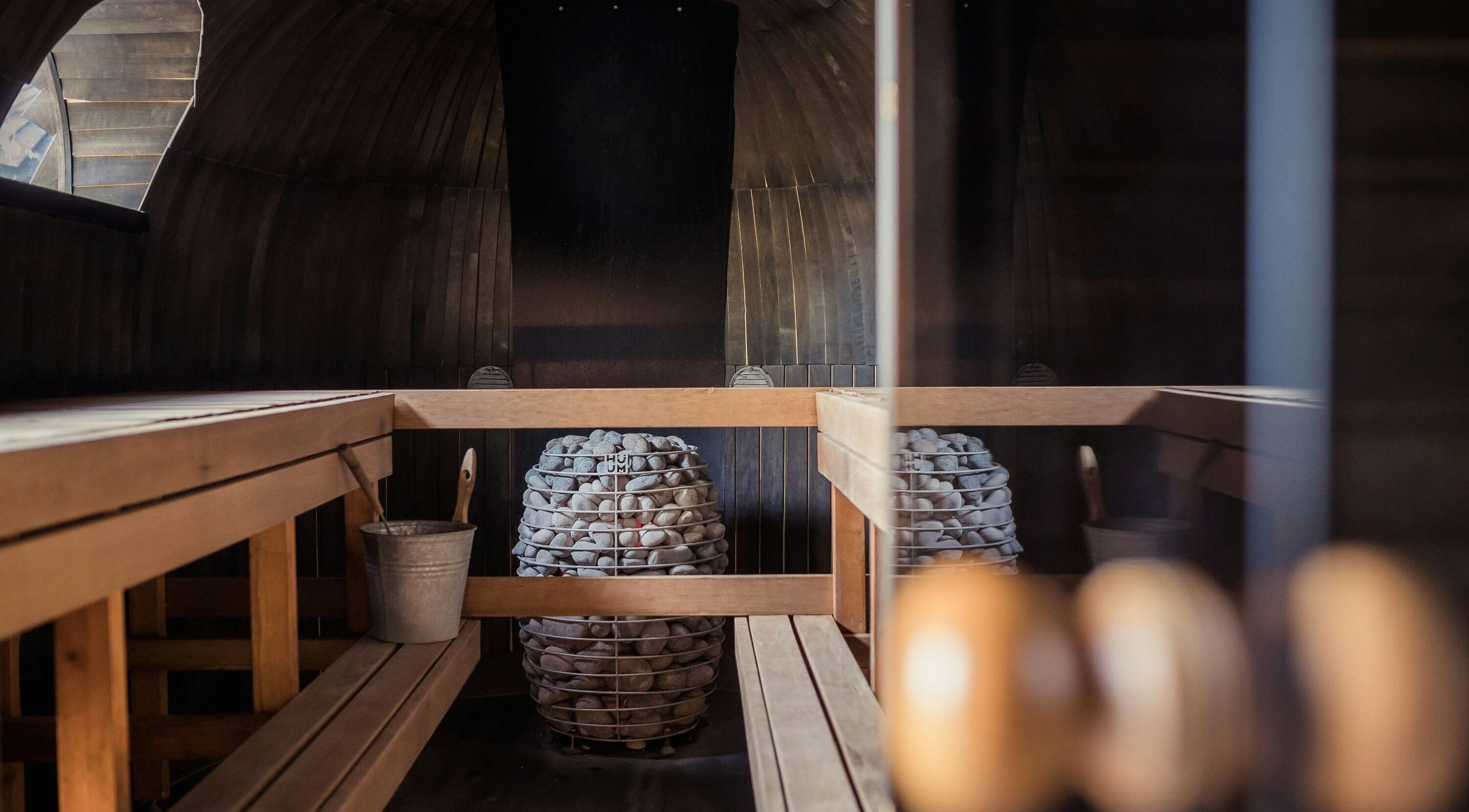 Cozy sauna room at Sari Kayangan Spa & Wellness, Sepang, Selangor, MY, featuring wooden benches and stone heater.