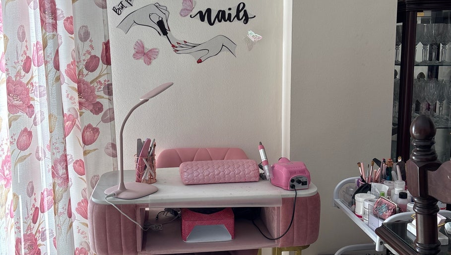 Estación de manicura en Judith Art Nails, Huelva, Andalucía, ES con decoraciones rosadas y herramientas de uñas.