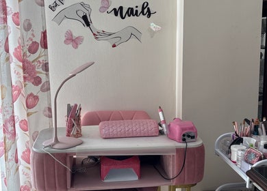 Estación de manicura en Judith Art Nails, Huelva, Andalucía, ES con decoraciones rosadas y herramientas de uñas.