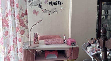 Estación de manicura en Judith Art Nails, Huelva, Andalucía, ES con decoraciones rosadas y herramientas de uñas.