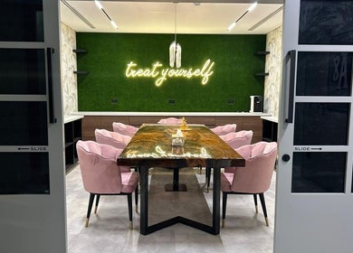 Cozy meeting area at Villa 8 Ladies Salon and Spa, Dubai, Dubai, AE with stylish chairs and neon decor.