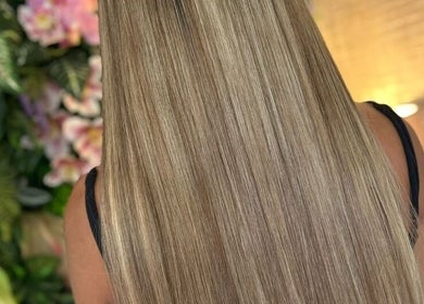 Smooth, long blonde hair at Bella Extensions in Sandbach, England, GB with a floral background.