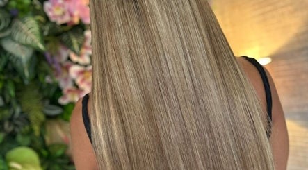 Smooth, long blonde hair at Bella Extensions in Sandbach, England, GB with a floral background.