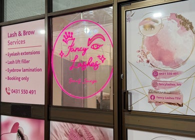 Entrance of Fancy Lashes TSV in Aitkenvale, Queensland, AU showcasing beauty services and neon logo.