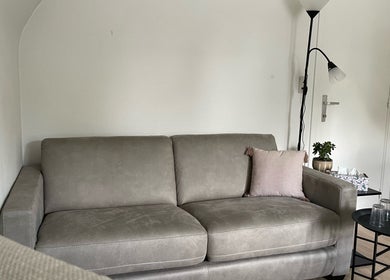 Comfortabele zitruimte met grijze bank in De Waterlelie, Nazareth-de Pinte, Vlaanderen, BE.