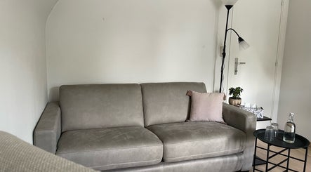 Comfortabele zitruimte met grijze bank in De Waterlelie, Nazareth-de Pinte, Vlaanderen, BE.