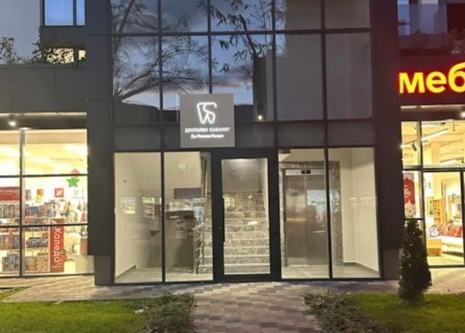 Exterior of Д-р Алимоллова- ендокринолог office in Asenovgrad, Plovdiv, BG with illuminated shops nearby.