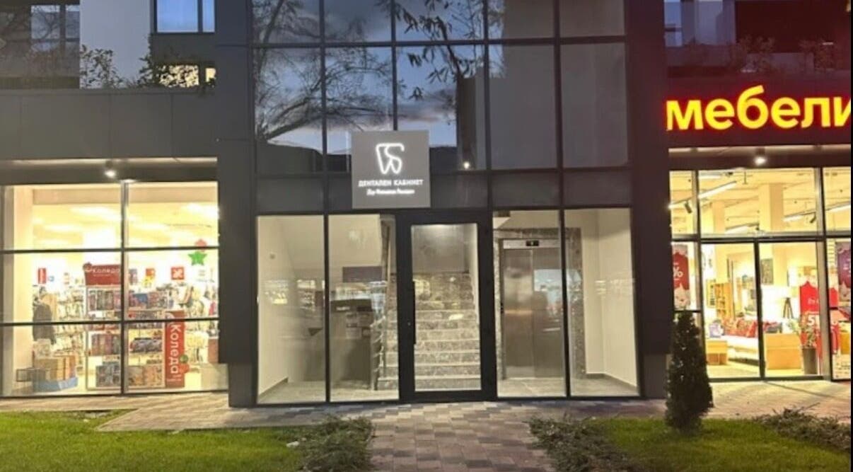 Exterior of Д-р Алимоллова- ендокринолог office in Asenovgrad, Plovdiv, BG with illuminated shops nearby.