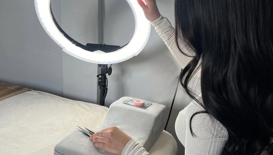 Professional lash application at Lashes by Amelia, Orpington, England, GB with precise tools under a ring light.